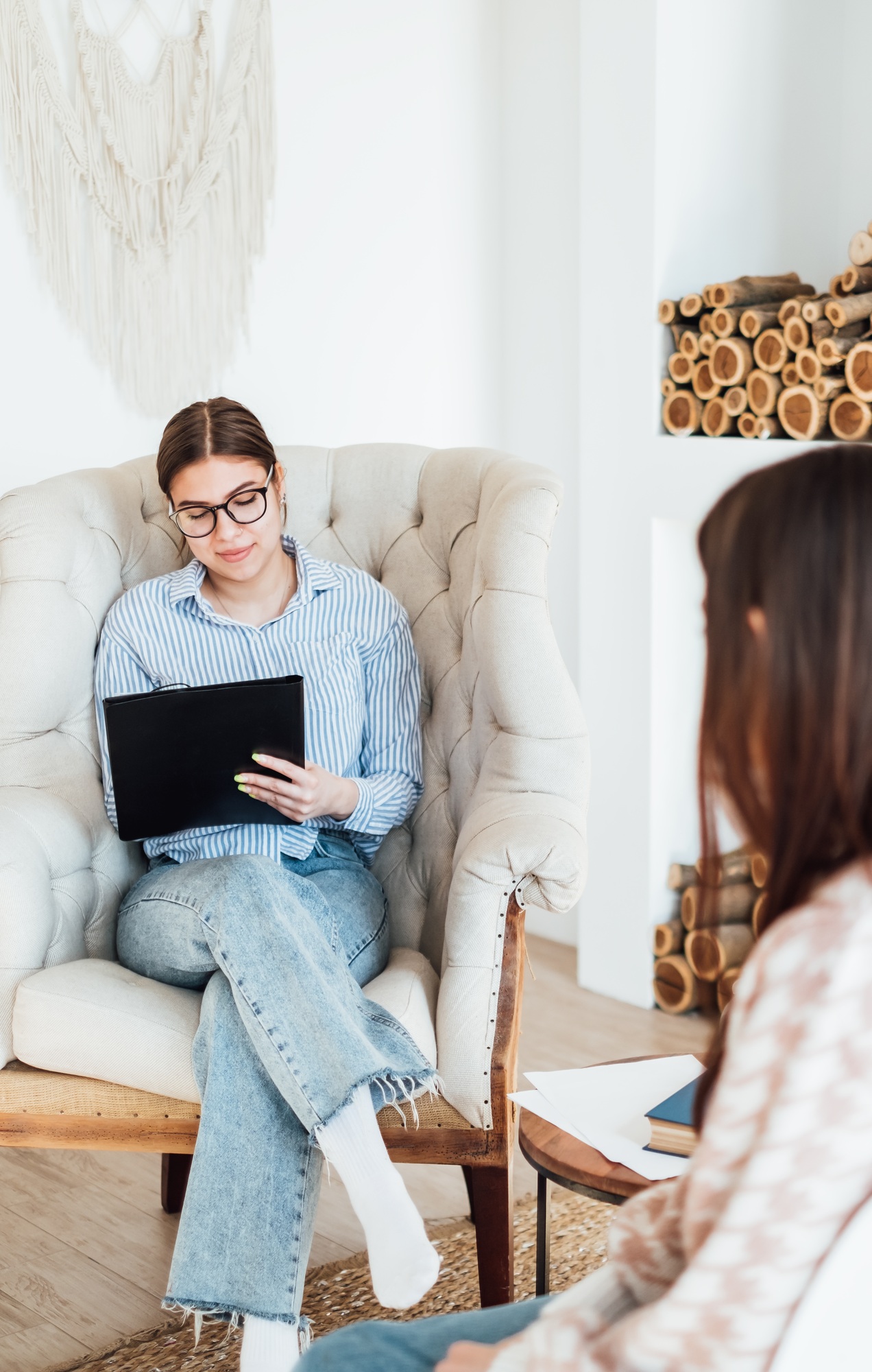 Caucasian woman psychologist in eyeglasses sitting in a chair at the workplace